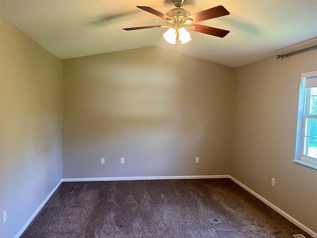 carpeted spare room featuring a textured ceiling, ceiling fan, vaulted ceiling, and baseboards