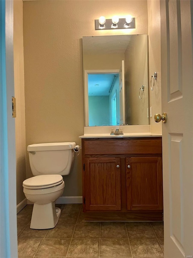 bathroom featuring toilet, tile patterned floors, and vanity