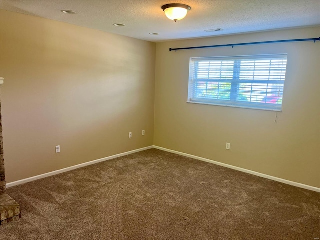 spare room with baseboards, carpet flooring, a textured ceiling, and visible vents