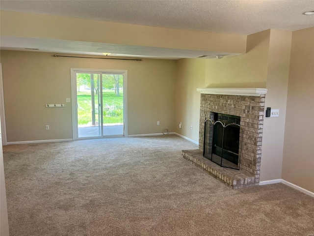 unfurnished living room featuring carpet floors, a textured ceiling, baseboards, and a brick fireplace