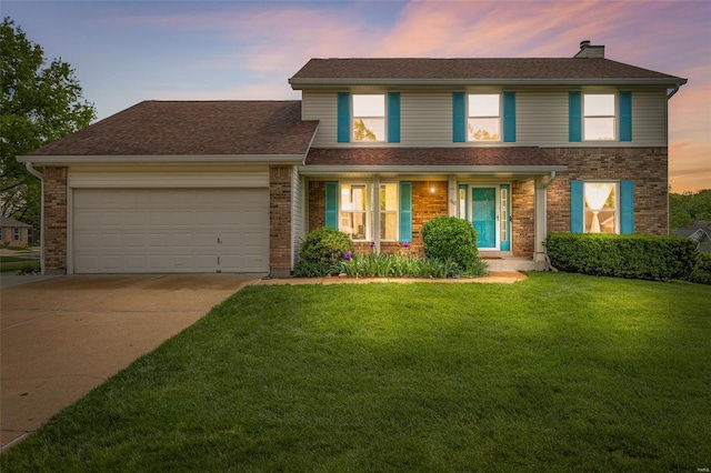 view of front of home featuring a garage, a lawn, concrete driveway, and brick siding