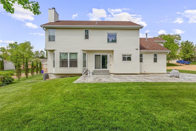 rear view of house with a lawn, a patio, a chimney, and entry steps