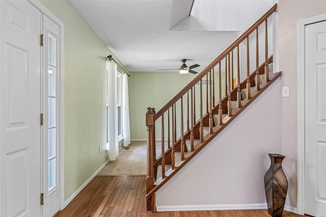 staircase with baseboards, a ceiling fan, and hardwood / wood-style floors