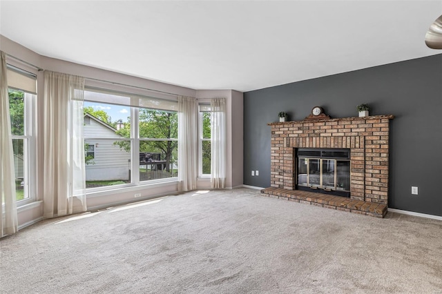 unfurnished living room featuring plenty of natural light, carpet flooring, baseboards, and a brick fireplace
