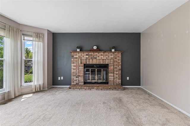 unfurnished living room with a brick fireplace, baseboards, visible vents, and carpet
