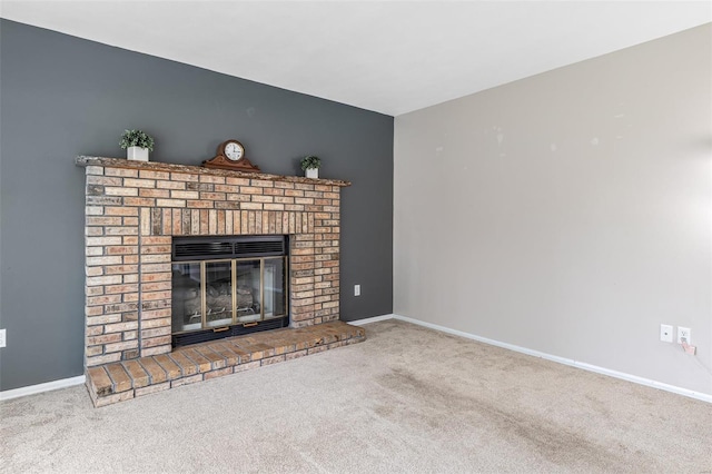 unfurnished living room with carpet floors, baseboards, and a brick fireplace