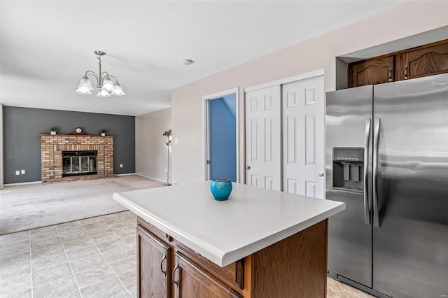 kitchen featuring light carpet, stainless steel fridge, light countertops, a center island, and a notable chandelier