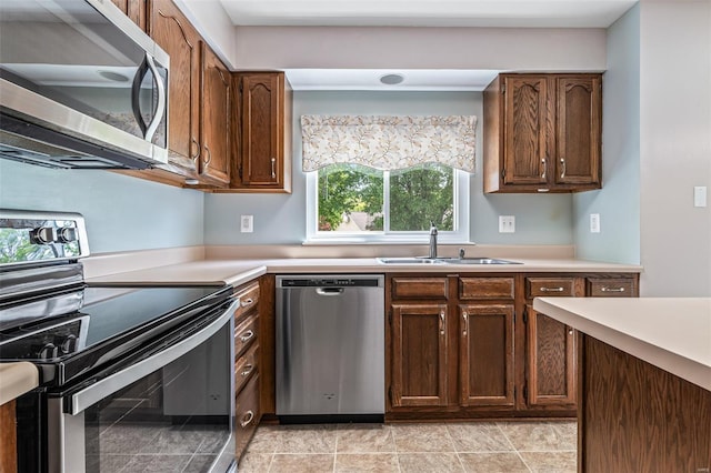 kitchen with light countertops, appliances with stainless steel finishes, and a sink