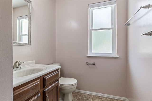 half bathroom featuring toilet, baseboards, tile patterned flooring, and vanity