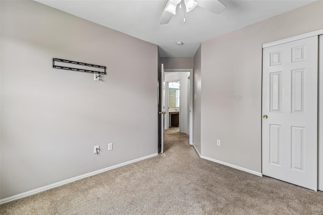 unfurnished bedroom featuring carpet floors, baseboards, and ceiling fan