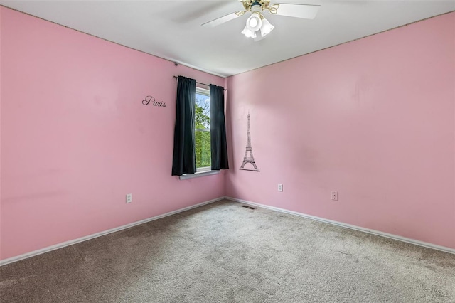 carpeted empty room featuring baseboards, ceiling fan, and visible vents