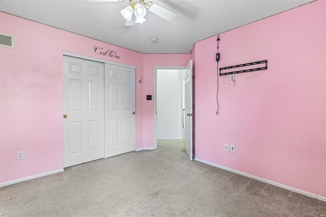 unfurnished bedroom featuring ceiling fan, light colored carpet, baseboards, visible vents, and a closet