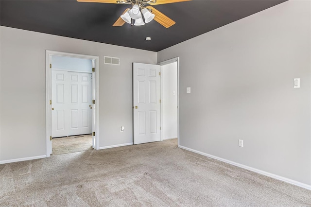 unfurnished bedroom with visible vents, carpet flooring, baseboards, and a ceiling fan
