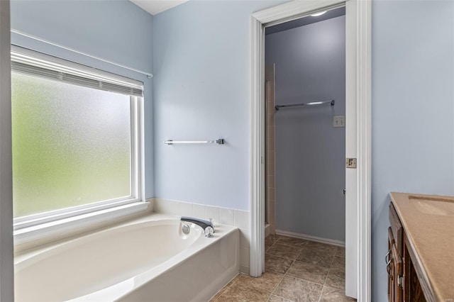 bathroom featuring a garden tub, a shower, and vanity