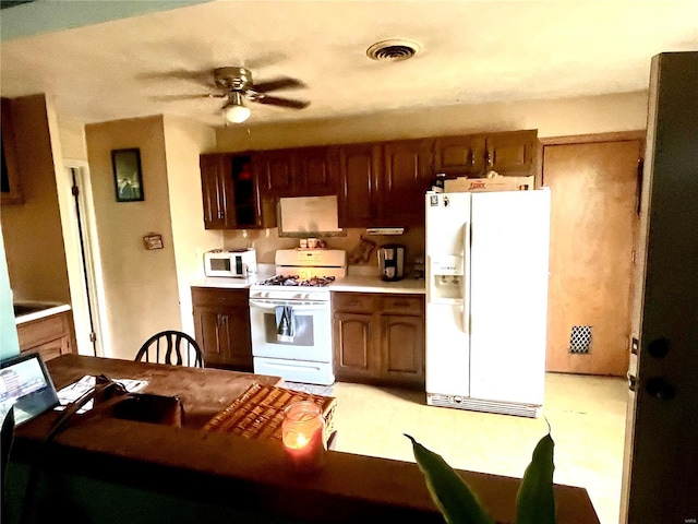 kitchen with visible vents, white appliances, a ceiling fan, and light countertops