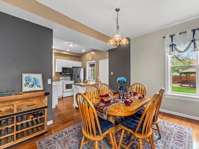 dining area featuring recessed lighting, baseboards, a healthy amount of sunlight, and wood finished floors