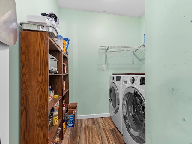 washroom featuring baseboards, laundry area, wood finished floors, and washer and clothes dryer