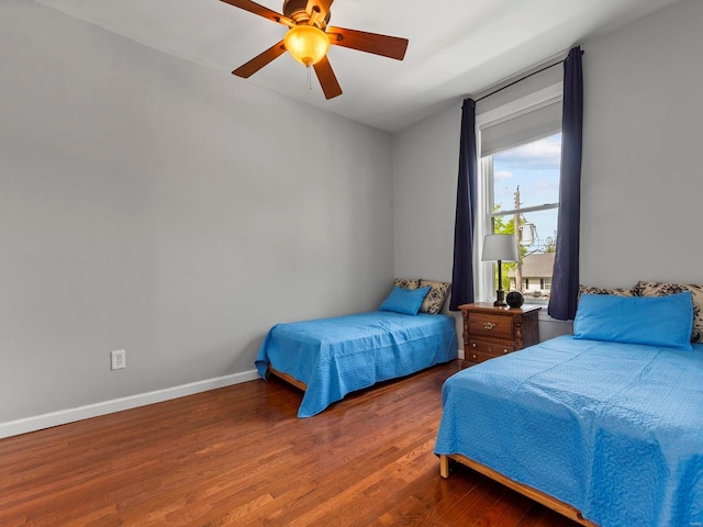 bedroom with baseboards, a ceiling fan, and wood finished floors