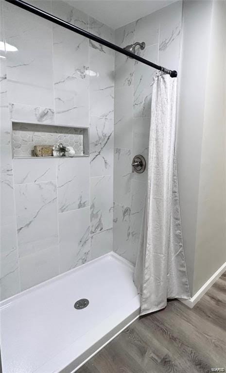 full bath with a shower stall and wood finished floors