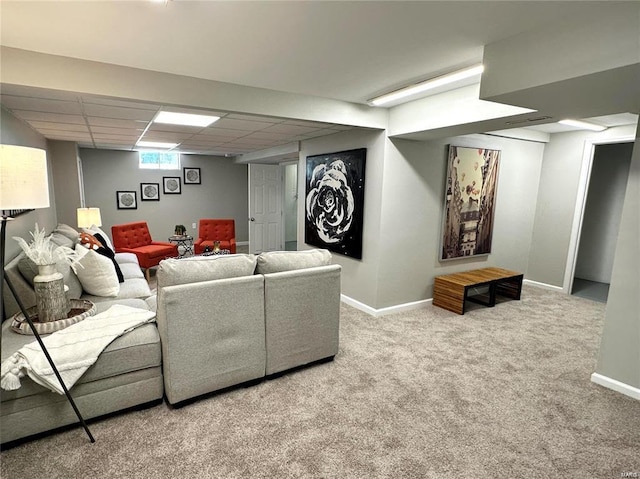 living area with carpet floors, baseboards, and a drop ceiling