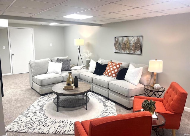 carpeted living area with baseboards and a paneled ceiling