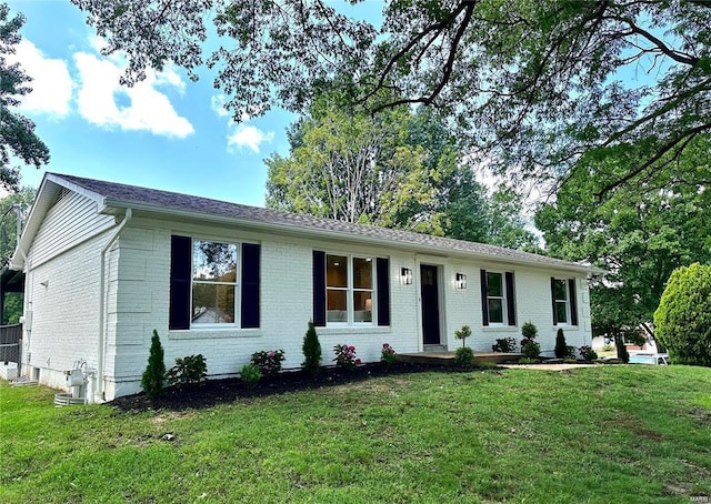 ranch-style house featuring a front yard and brick siding