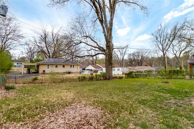 view of yard with fence and a carport