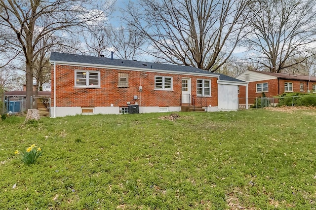 back of house featuring brick siding, fence, cooling unit, a yard, and entry steps