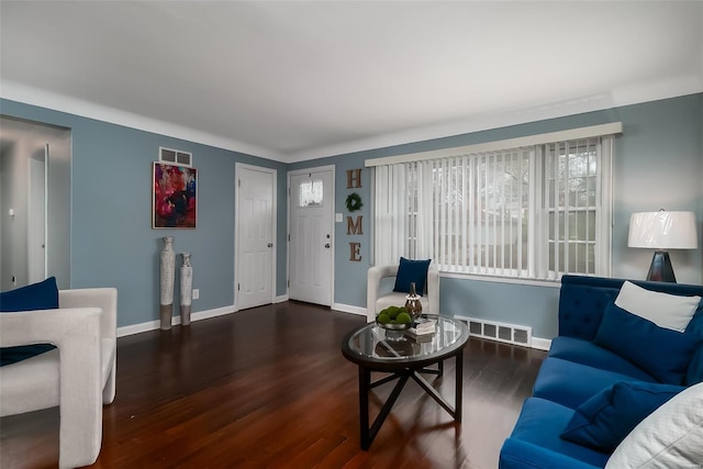 living room featuring visible vents, baseboards, and wood finished floors