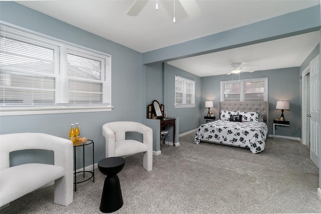 carpeted bedroom with baseboards, multiple windows, and a ceiling fan