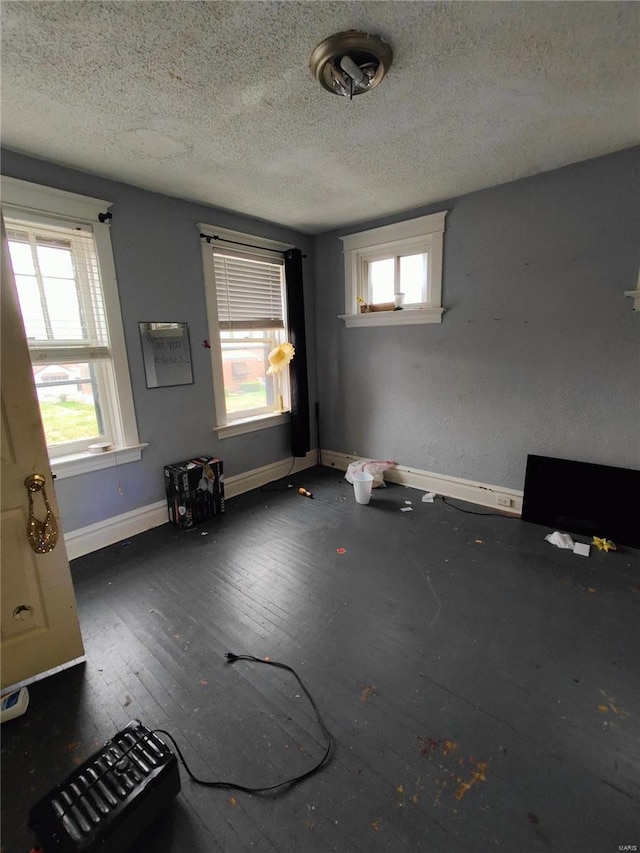 interior space with baseboards, plenty of natural light, and a textured ceiling