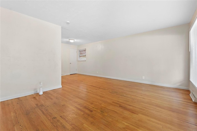spare room featuring light wood finished floors and baseboards