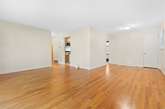 unfurnished living room featuring light wood-type flooring, visible vents, baseboards, and a baseboard radiator