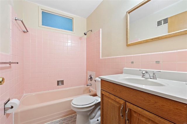 bathroom featuring bathtub / shower combination, tile walls, toilet, vanity, and visible vents