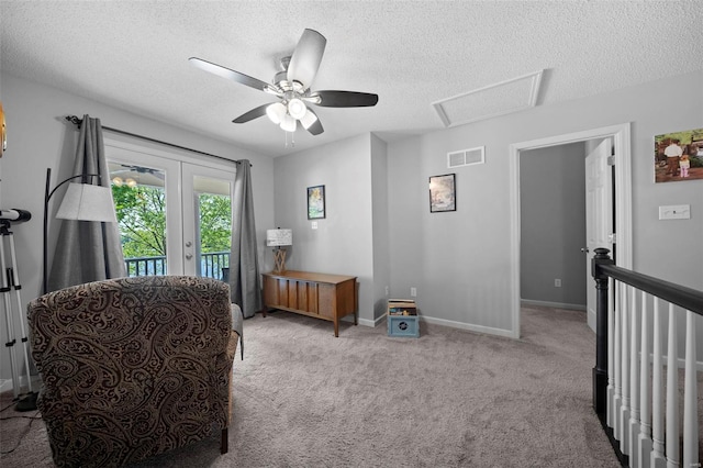 sitting room with carpet floors, a ceiling fan, a textured ceiling, and visible vents