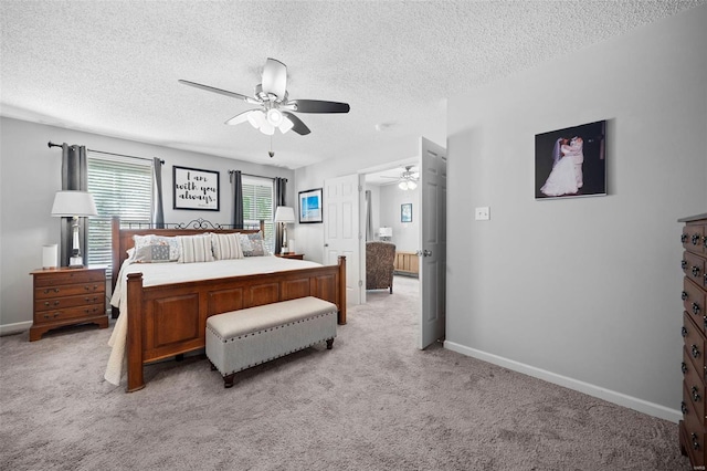 bedroom with light colored carpet, a textured ceiling, and baseboards