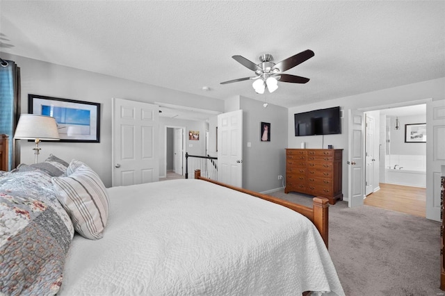 carpeted bedroom featuring baseboards, connected bathroom, a textured ceiling, and ceiling fan