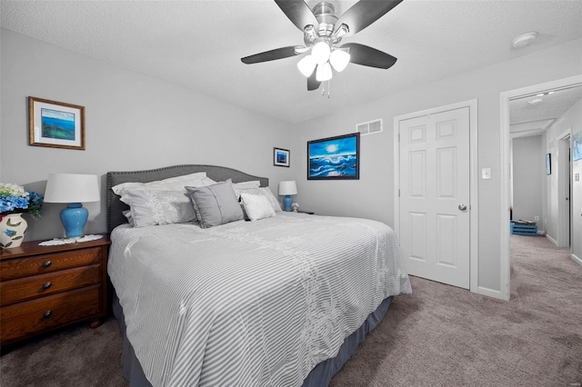 carpeted bedroom featuring visible vents, a ceiling fan, baseboards, and a textured ceiling