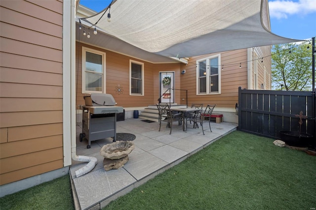 rear view of property featuring a lawn, a patio, and fence