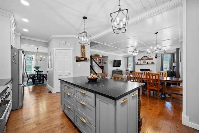 kitchen with freestanding refrigerator, pendant lighting, a kitchen island, hardwood / wood-style flooring, and gray cabinetry