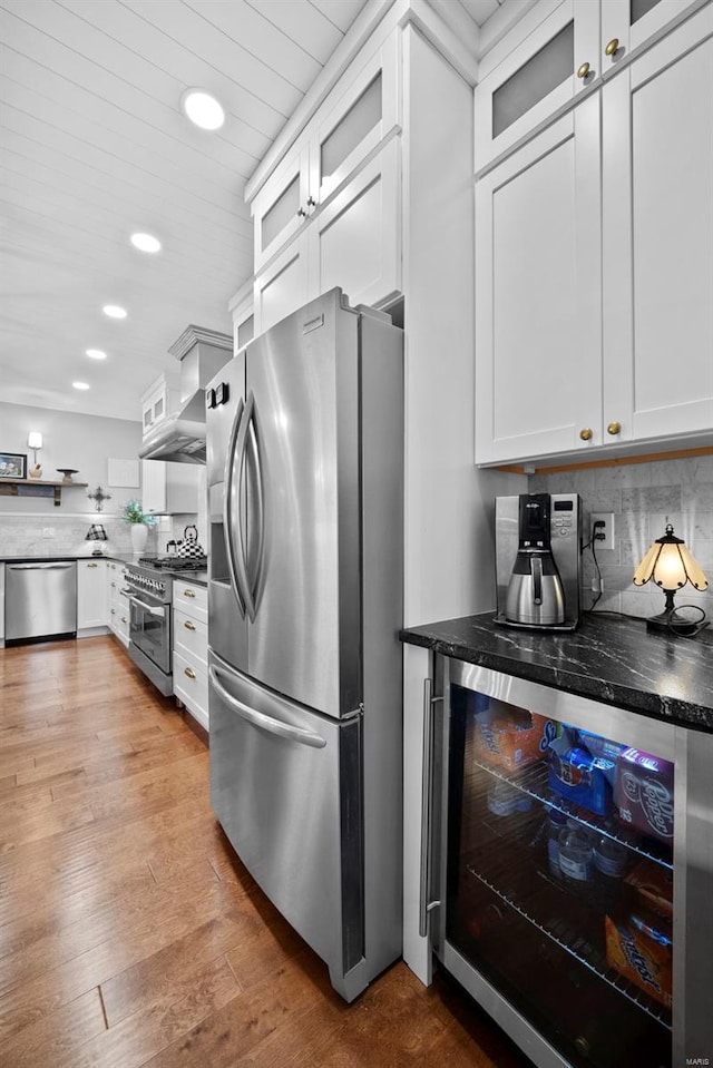 kitchen with decorative backsplash, beverage cooler, recessed lighting, white cabinetry, and appliances with stainless steel finishes