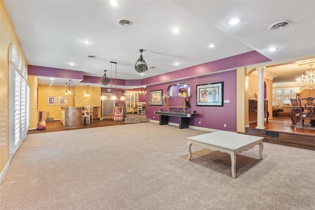 living area with a dry bar, ornate columns, visible vents, carpet flooring, and baseboards