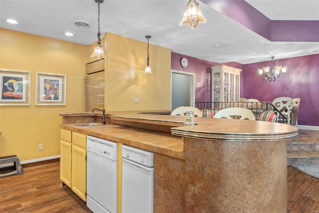 kitchen with white dishwasher, baseboards, dark wood-style flooring, hanging light fixtures, and a sink