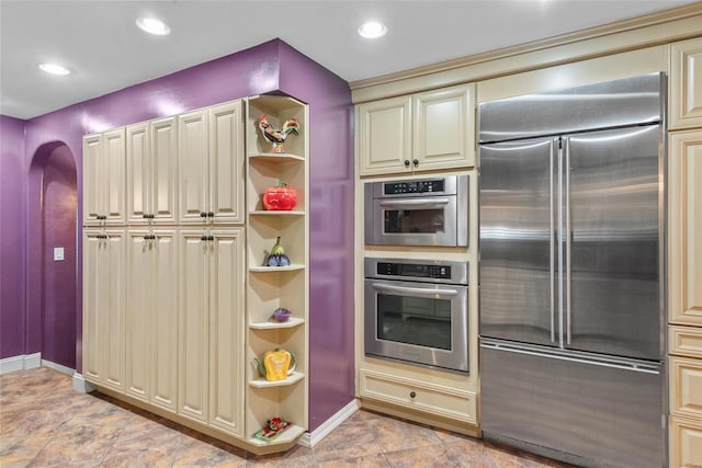 kitchen featuring cream cabinets, open shelves, built in refrigerator, and baseboards