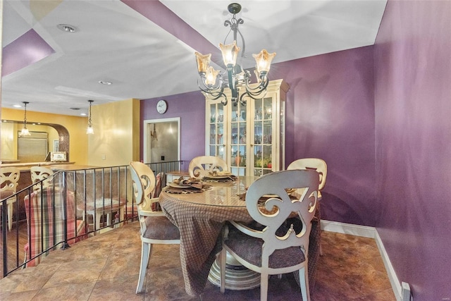dining space featuring a notable chandelier and baseboards