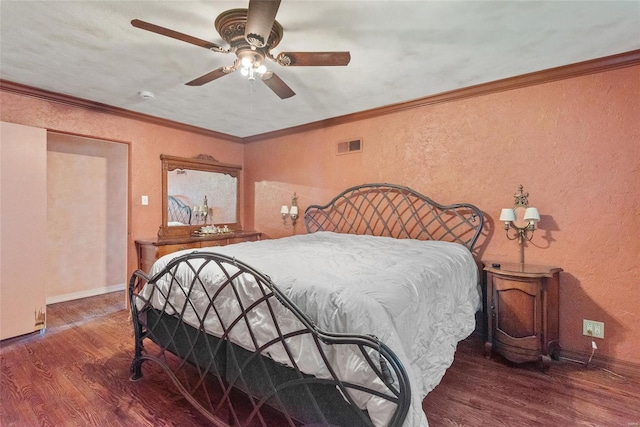 bedroom featuring ceiling fan, a textured wall, visible vents, and wood finished floors