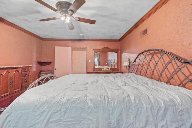 bedroom with ceiling fan, visible vents, ornamental molding, and a textured wall
