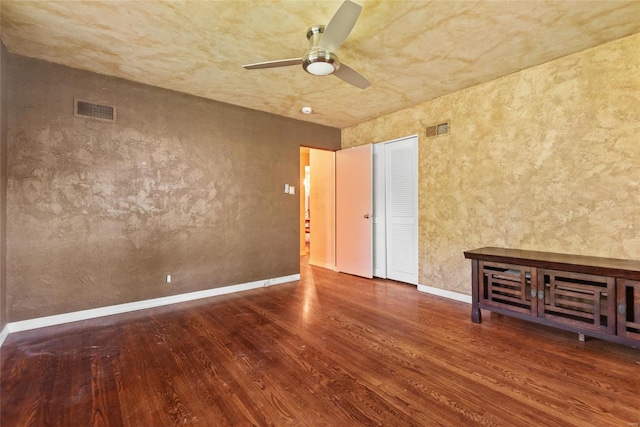 unfurnished room featuring baseboards, a ceiling fan, visible vents, and wood finished floors