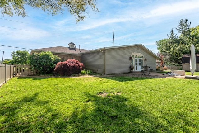back of house featuring a yard, a fenced backyard, and a patio