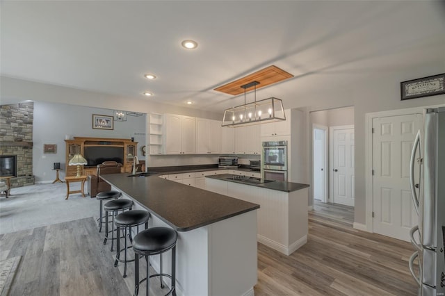 kitchen featuring a fireplace, dark countertops, stainless steel appliances, and a center island